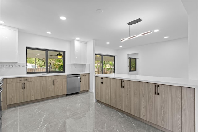 kitchen with a wealth of natural light, pendant lighting, white cabinets, and stainless steel dishwasher