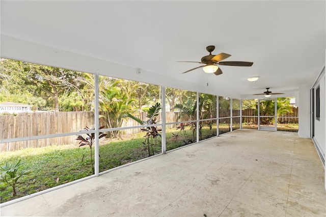 unfurnished sunroom with ceiling fan