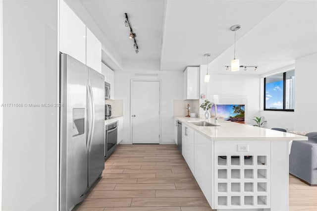 kitchen with white cabinets, kitchen peninsula, sink, and stainless steel appliances