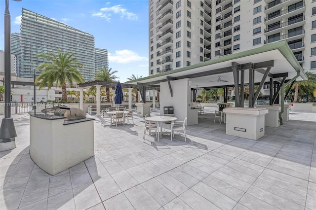 view of patio with ceiling fan and area for grilling