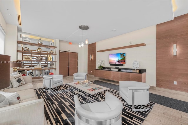 living room with hardwood / wood-style floors, plenty of natural light, and wooden walls