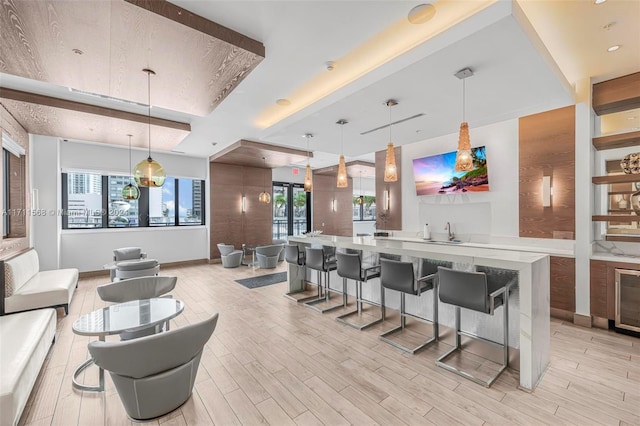 interior space with light hardwood / wood-style flooring, hanging light fixtures, and sink