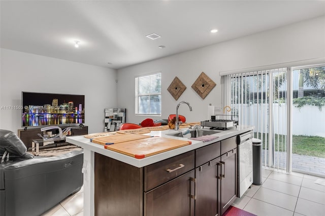 kitchen featuring dishwasher, dark brown cabinets, sink, and an island with sink