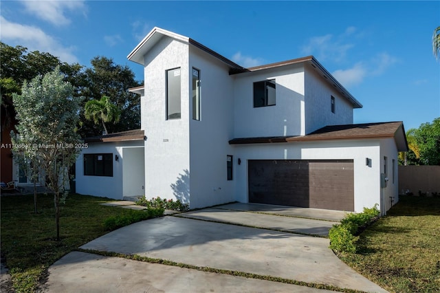 contemporary home with a garage, stucco siding, driveway, and a front yard