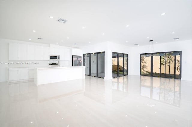 interior space with visible vents, white cabinets, a large island, stainless steel appliances, and recessed lighting