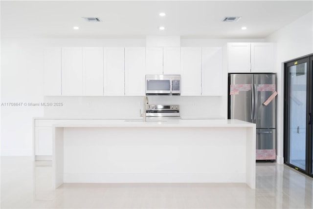 kitchen featuring white cabinets, visible vents, and stainless steel appliances