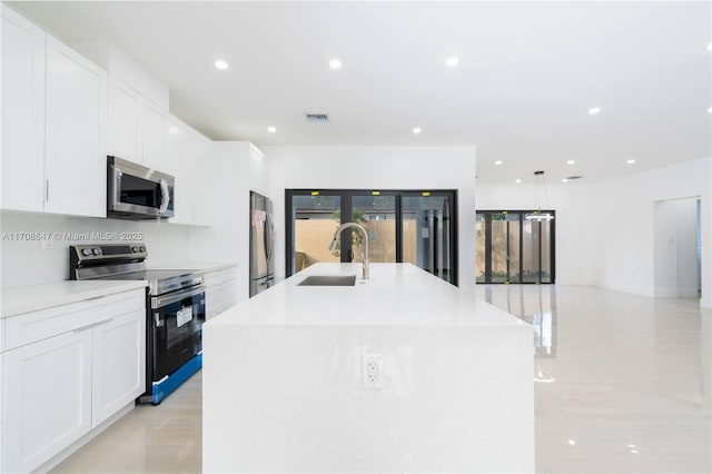 kitchen with recessed lighting, stainless steel appliances, a sink, visible vents, and a center island with sink