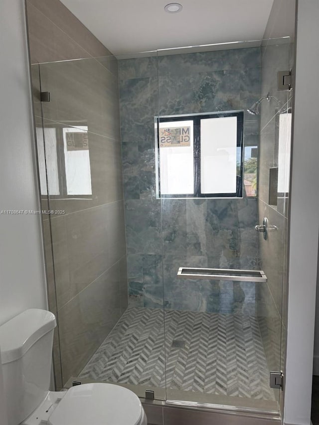 full bathroom featuring a stall shower and toilet