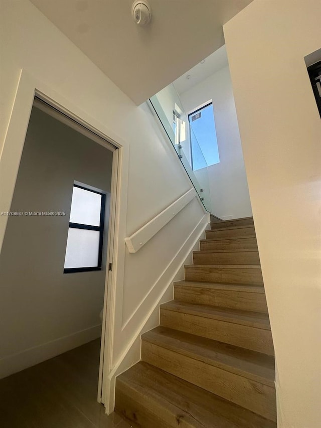 stairway with baseboards and wood finished floors