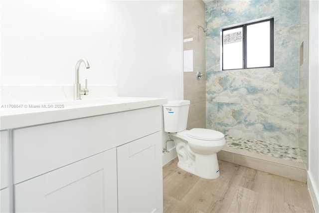 full bathroom featuring vanity, wood finished floors, a shower stall, and toilet