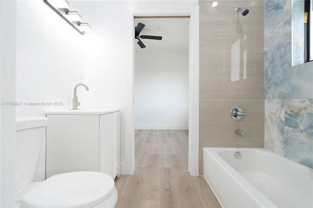 bathroom featuring toilet, a ceiling fan, vanity, wood finished floors, and  shower combination