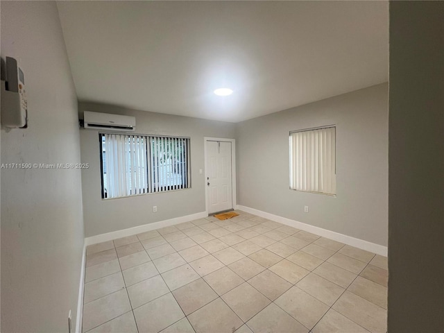 unfurnished room with a wall mounted AC and baseboards