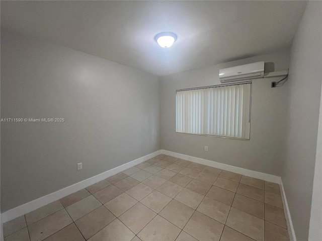 spare room with baseboards, a wall mounted AC, and light tile patterned floors