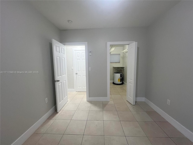 unfurnished bedroom featuring light tile patterned floors and baseboards