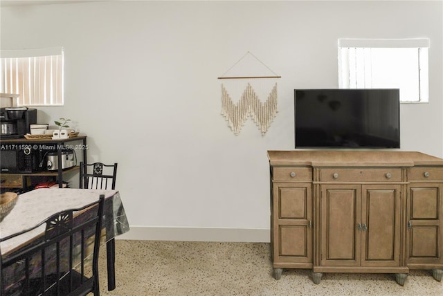 interior space with baseboards and light speckled floor