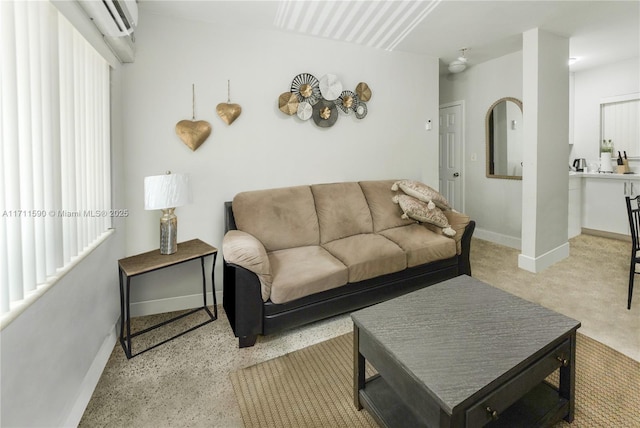 living area featuring baseboards and a wall mounted air conditioner