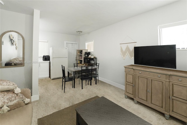living area featuring baseboards and light speckled floor