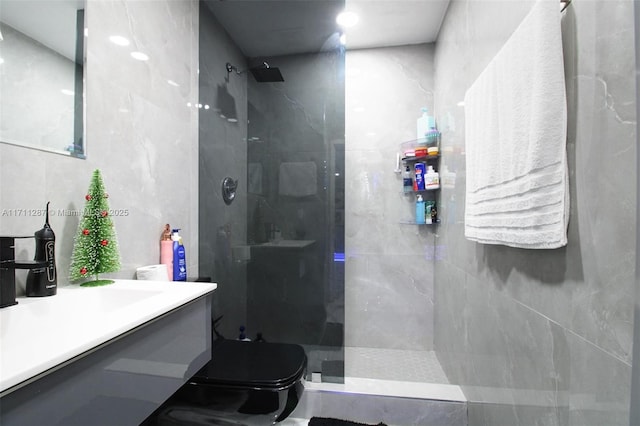 bathroom with a tile shower, tile walls, and toilet