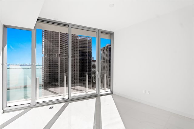 empty room featuring expansive windows and a water view