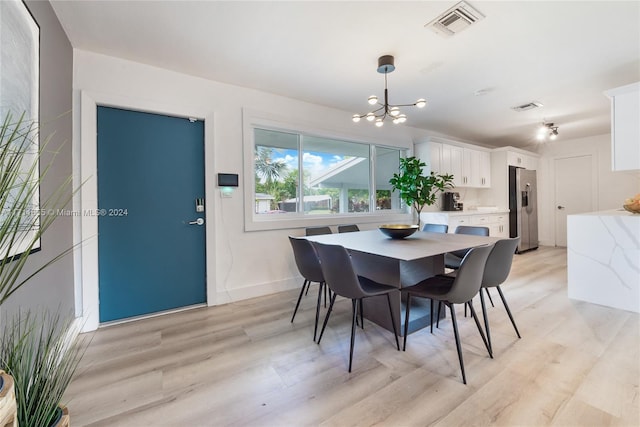 dining space featuring a notable chandelier and light hardwood / wood-style floors