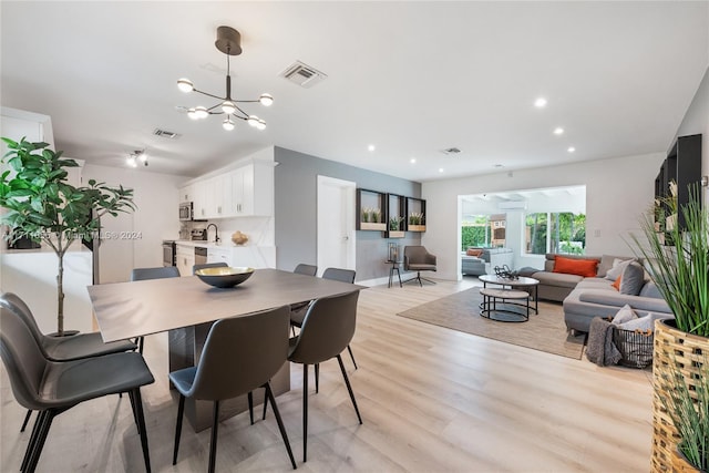 dining space with an inviting chandelier and light wood-type flooring