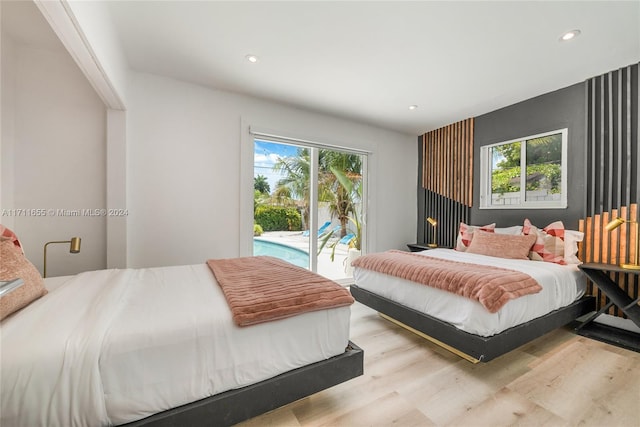 bedroom featuring access to exterior, light wood-type flooring, and multiple windows