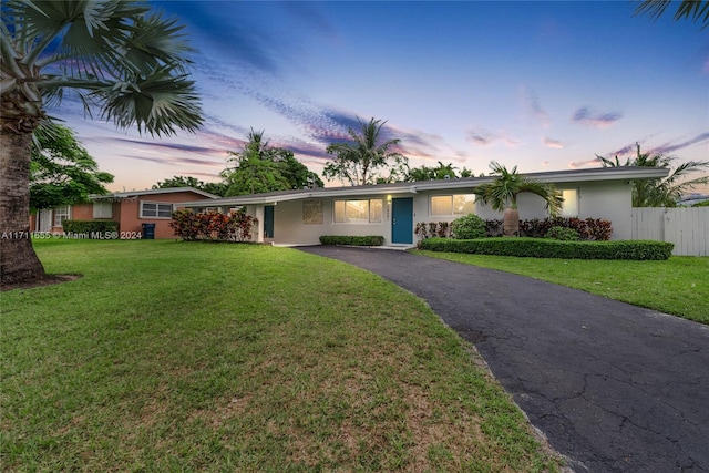 ranch-style home featuring a yard