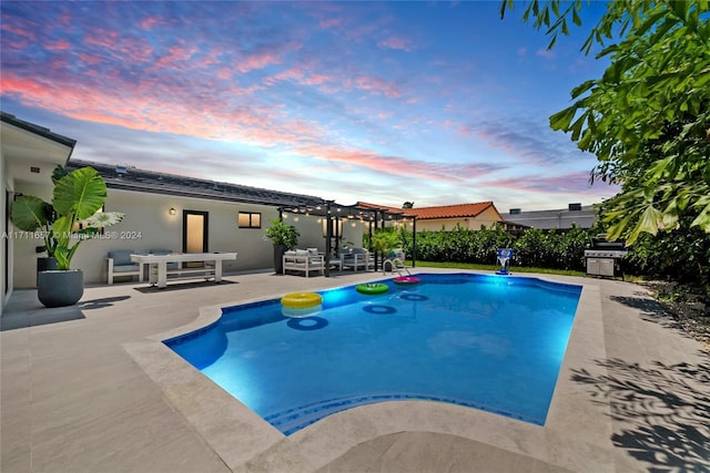 pool at dusk with a patio area