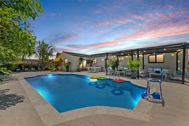 pool at dusk featuring outdoor lounge area and a patio