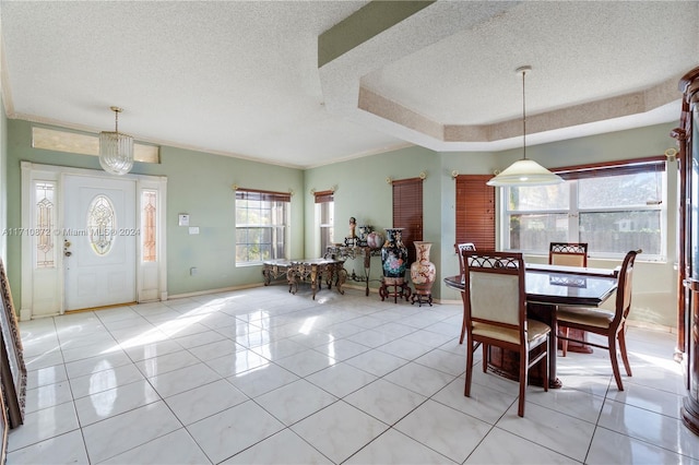 dining area with light tile patterned floors, a textured ceiling, and ornamental molding