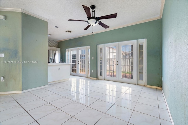 tiled spare room featuring ceiling fan, french doors, a textured ceiling, and ornamental molding