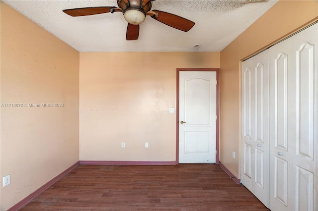 unfurnished bedroom featuring a textured ceiling, ceiling fan, dark wood-type flooring, and a closet