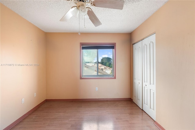 unfurnished bedroom with ceiling fan, light hardwood / wood-style floors, a textured ceiling, and a closet