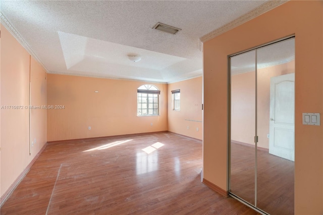 unfurnished bedroom featuring hardwood / wood-style floors, a textured ceiling, and ornamental molding