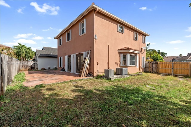 back of house with a lawn, a patio area, and central air condition unit