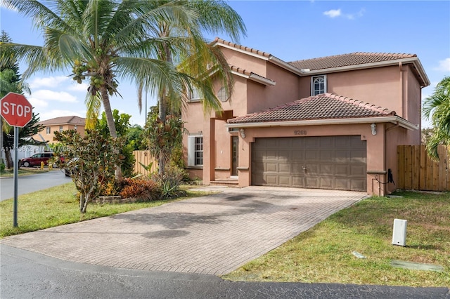 mediterranean / spanish-style home featuring a garage and a front lawn