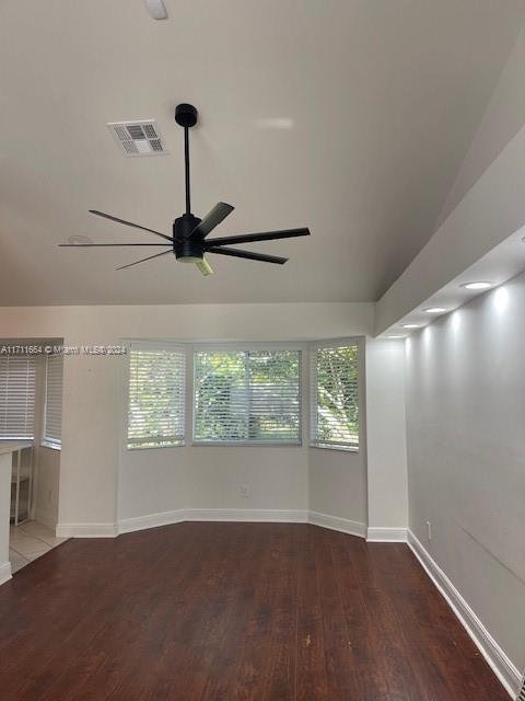 spare room with ceiling fan, lofted ceiling, and dark wood-type flooring