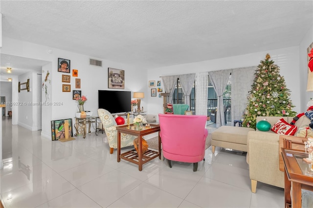 tiled living room featuring a textured ceiling