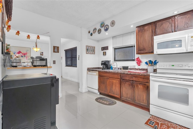 kitchen featuring sink, pendant lighting, a textured ceiling, white appliances, and light tile patterned flooring