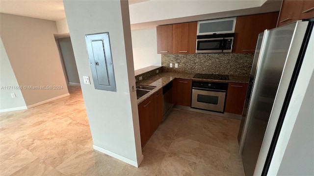 kitchen featuring electric panel, sink, decorative backsplash, dark stone countertops, and appliances with stainless steel finishes