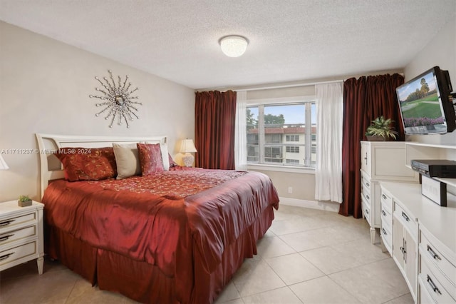 bedroom featuring a textured ceiling and light tile patterned floors