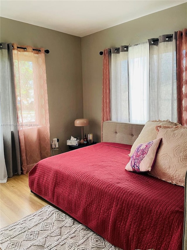 bedroom with multiple windows and light hardwood / wood-style floors