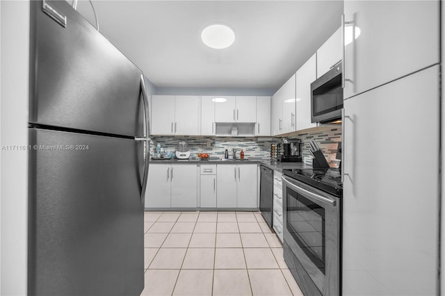 kitchen with sink, light tile patterned floors, backsplash, white cabinets, and appliances with stainless steel finishes