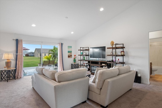 carpeted living room with high vaulted ceiling