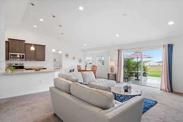 carpeted living room featuring sink and vaulted ceiling