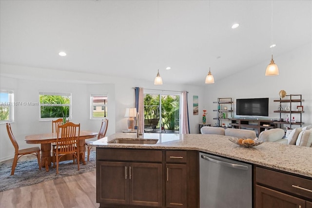 kitchen with light stone countertops, hanging light fixtures, stainless steel dishwasher, lofted ceiling, and light wood-type flooring