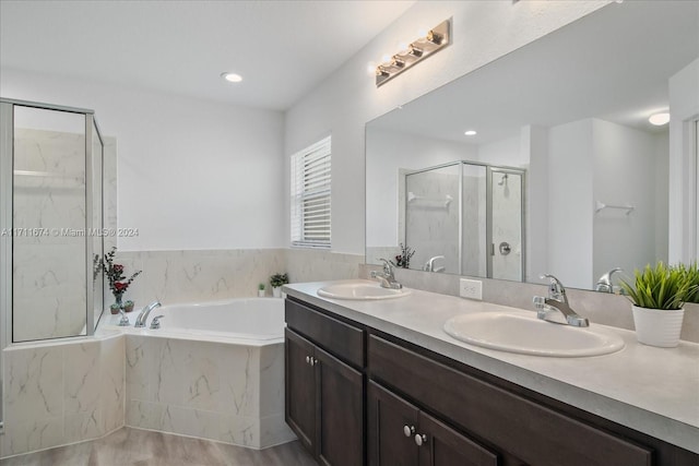 bathroom featuring hardwood / wood-style floors, vanity, and separate shower and tub