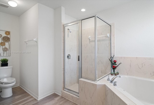 bathroom featuring hardwood / wood-style flooring, separate shower and tub, and toilet