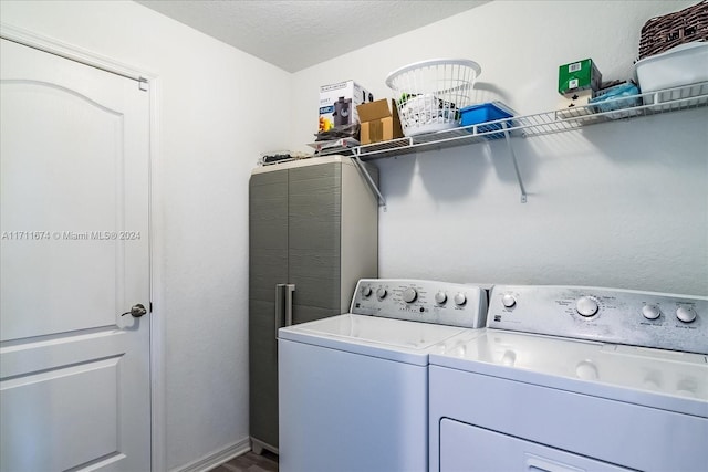 laundry room with washer and dryer and a textured ceiling