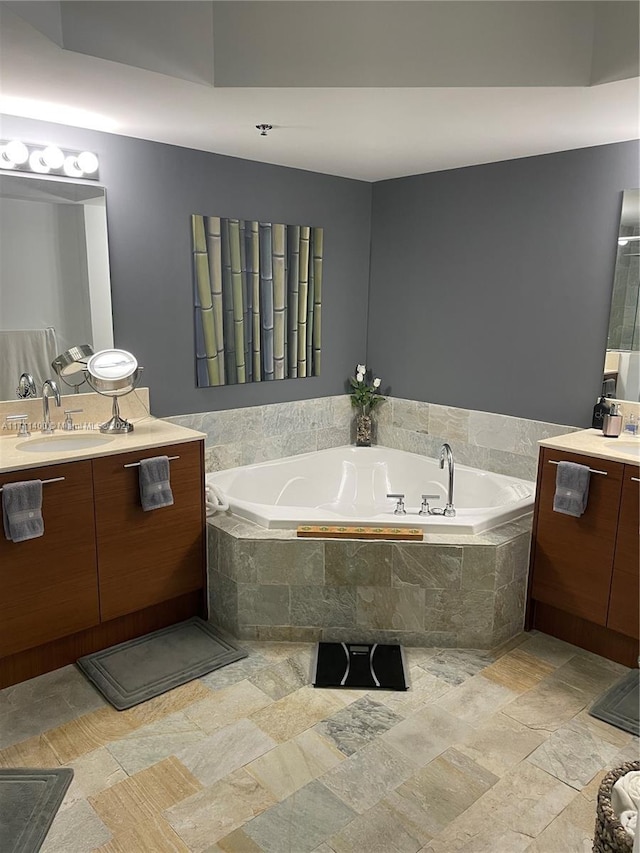 bathroom with tiled bath and vanity